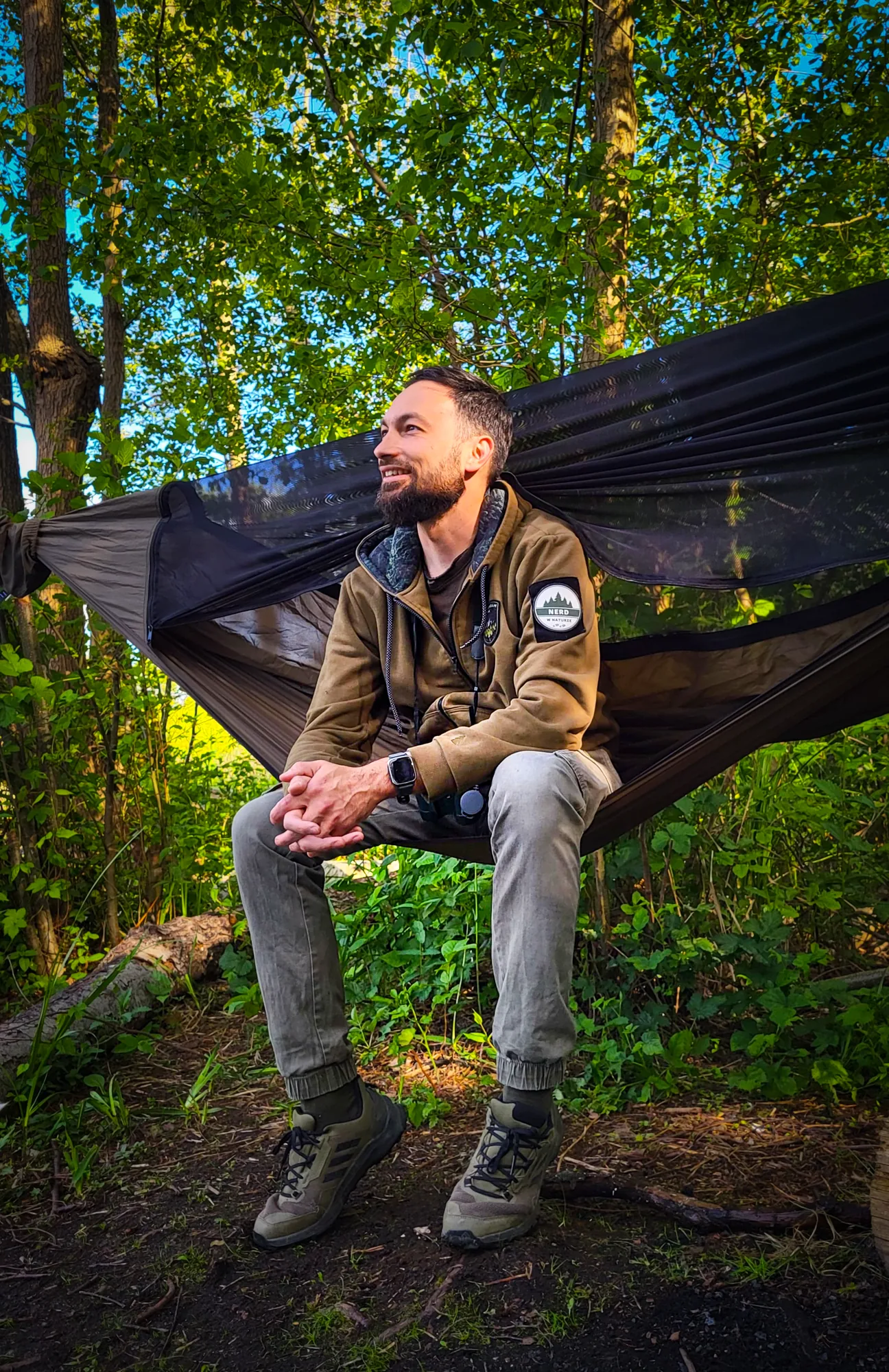 Adam Wiernasz beside a hammock in a green forest
